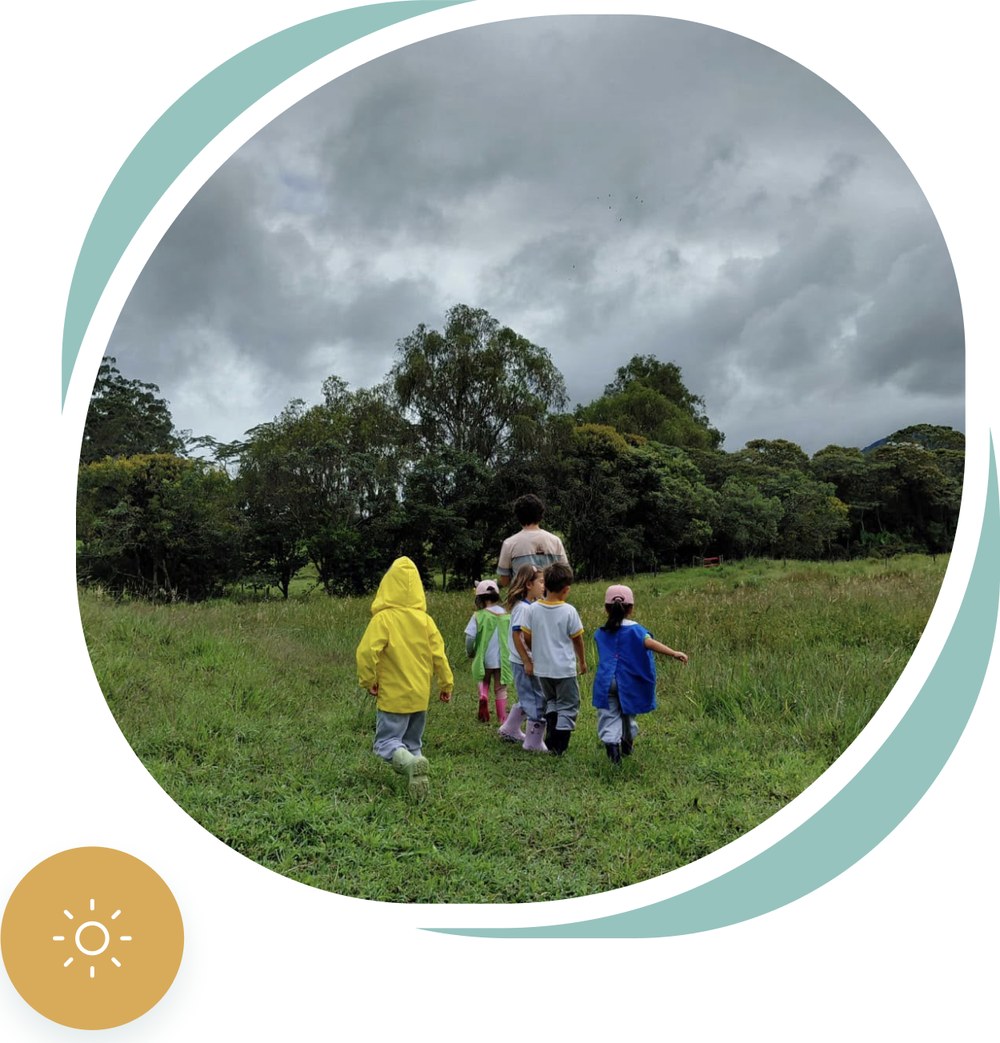 Niños de Terra Vita caminando por el campo con su maestra