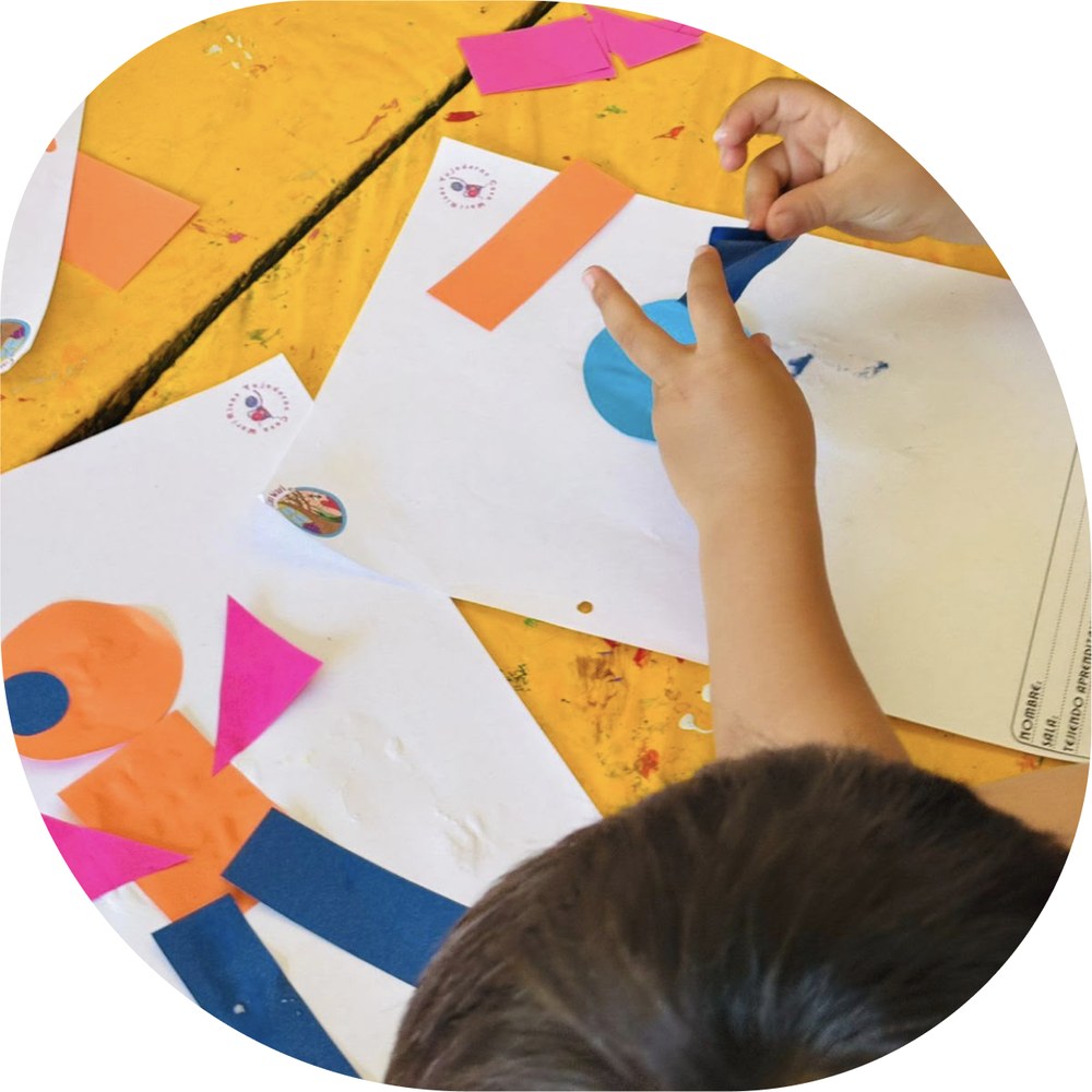 Niño creando una figura con papeles de colores